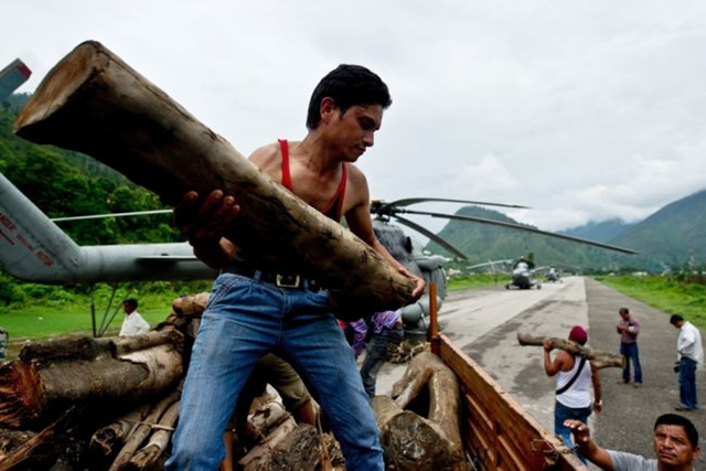 Indian workers offload wood, to be carried to Kedarnath by the Indian Air Force for cremation preparations, at Gauchar Airfield in Uttarakhand state on 25 June 2013. Around 1,000 people have been killed in flash floods and landslides in northern India. Photo: Global Post