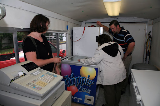 KSMU's Michele Skalicky listens as Lisa Brenneman inspects a vendor's trailer. Photo Credit: Alex Crowder