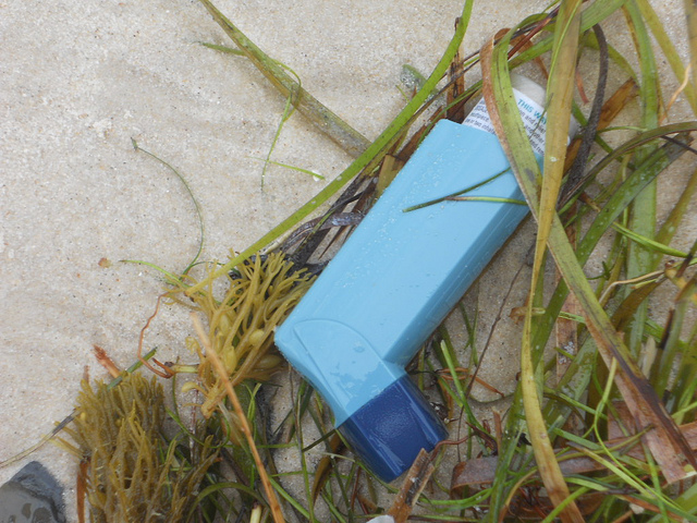 A discarded asthma inhaler that has washed up on a beach. mikecogh / flickr