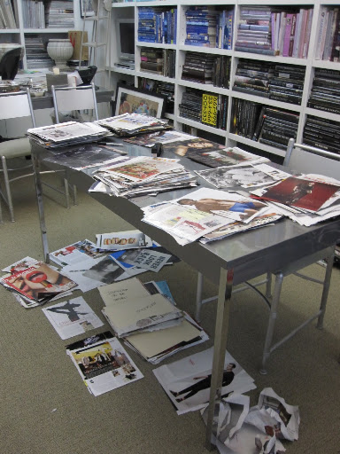 My office table that is supposed to be cleared off so I can have meetings at it with other editors. Even the floor below the table is a mess.