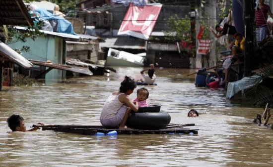 Filipino villagers make their way in a flooded street in Calumpit, north of Manila, Philippines, on 03 October 2011. President Benigno Aquino III said that his cabinet is meeting to create rehabilitation plans for the areas affected by the recent typhoons Nesat and Nalgae. According to the Office of Civil Defense, typhoon Nalgae has so far left one person dead, while 57 people died and 30 were missing in typhoon Nesat's onslaught, which also flooded central Manila. EPA / DENNIS M. SABANGAN