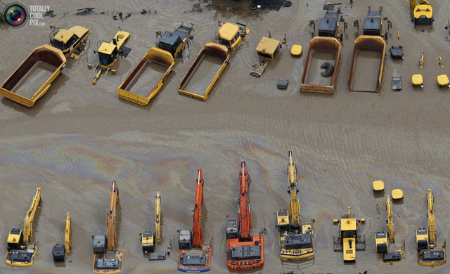 Heavy equipment sits submerged in flood waters in an industrial area of Brisbane 13 January 2011. Flood water in Australia's third-biggest city peaked below feared catastrophic levels but Brisbane and other devastated regions faced years of rebuilding and even the threat of fresh floods in the weeks ahead. Photo: Tim Wimborne / REUTERS