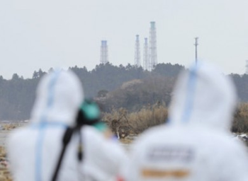 The exhaust stacks of the Fukushima Daiichi plant tower, seen above the surrounding woodland. AP Photo / Kyodo News