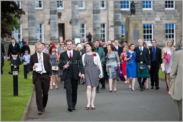 wedding guests follow pipe band to dinner