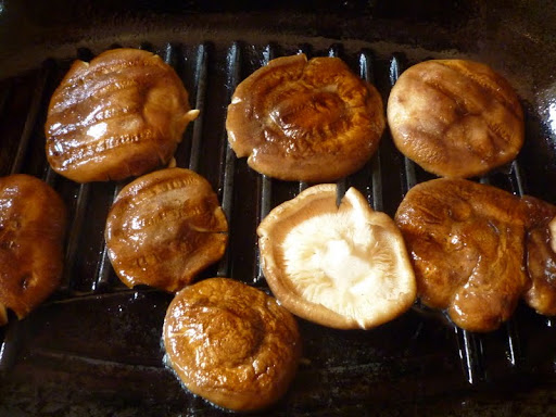Shiitake mushrooms getting grilled.