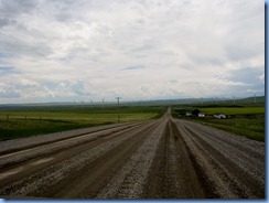 1183 Alberta - gravel roads between Head-Smashed-In Buffalo Jump Interpretive Centre and Pincher Creek - canola field   wind turbines   mountains ahead
