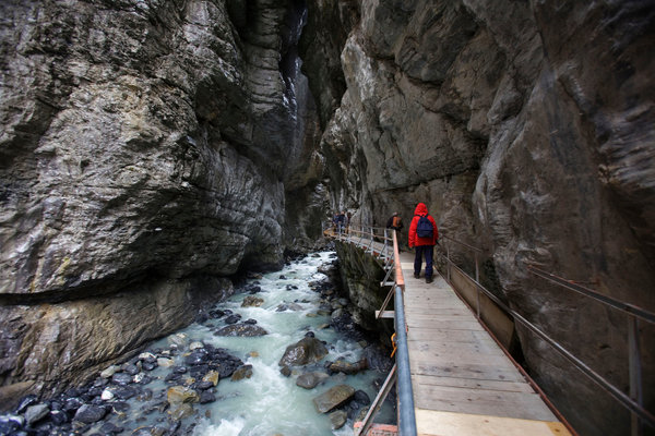 Tourists walking along a stream originating from the Lower Grindelwald Glacier in Switzerland. The glacier once extended through the gorge. Photo Christoph Bangert / The New York Times