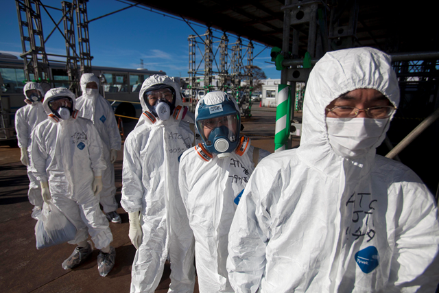 Workers in protective suits wait to enter the damaged nuclear power facility in Fukushima, Japan, 5 March 2012. battleland.blogs.time.com