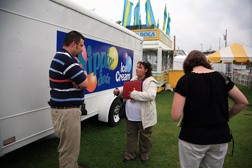 KSMU's Michele Skalicky listens as Lisa Brenneman inspects a vendor's trailer. Photo Credit: Alex Crowder