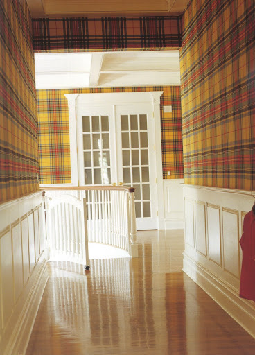 The overscaled yellow tartan wallcovering resonates like a piece of Pop art.
