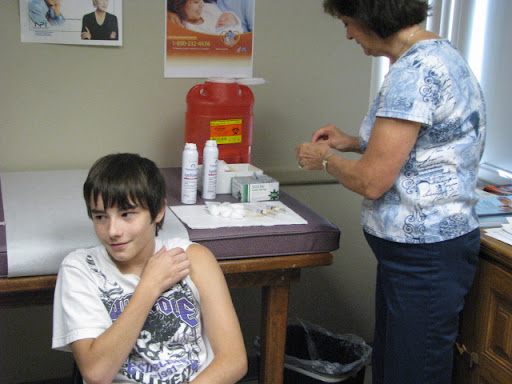 Nurse Leslie Davis prepares to give Dalton Church his shots