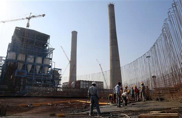 In this 24 February 2015 photo, workers lay cement to build a concrete structure at the under-construction coal-fired power plant, partially financed by the Japan Bank for International Cooperation, in Kudgi, India. Despite mounting protests, Japan continues to finance the building of coal-fired power plants with money earmarked for fighting climate change, with two new projects underway in India and Bangladesh, The Associated Press has found. Photo: Aijaz Rahi / AP