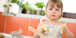 Child baking - little girl kneading dough