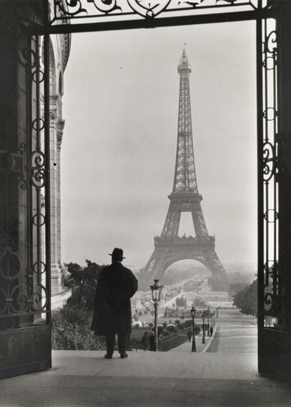 Man looks out on the Eiffel Tower.