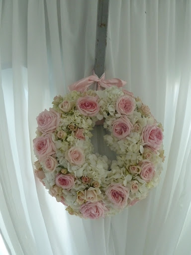The wreath was repurposed after the newlyweds arrived at the reception. Since there were two (for the front and the back of the car) they were hung on the sides of the tent's entryway. The wreath was repurposed after the newlyweds arrived at the reception. Since there were two (for the front and the back of the car) they were hung on the sides of the tent's entryway.