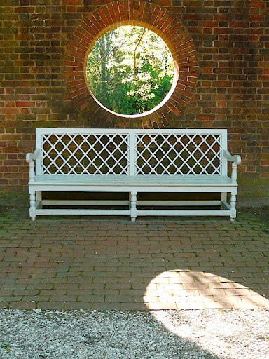A perfect circle void in the garden wall offset by the geometry of the bench. This is classic, timeless garden design.
