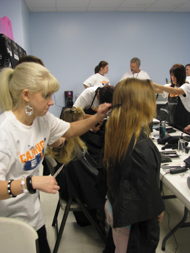A volunteer concentrates while giving a back to school haircut. (photo credit: Matt Evans)