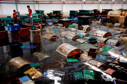 Aapico Hitech Pcl workers recover containers and raw steel rolls at the company’s flooded factory in the Hi Tech Industrial estate, Ayutthaya, Thailand. Bloomberg