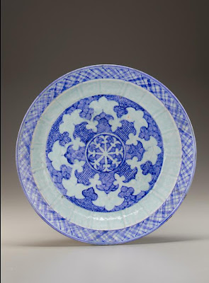 Charger | Origin:  Iran | Period: mid-15th century  Timurid period | Details:  Timurid production of blue-and-white ceramics flourished in fifteenth-century Iran. The decoration of this large molded plate centers on a wheel-like motif. Its stylized octafoil design of alternating scale and wave patterns was adapted from Chinese models. The plate illustrates the Timurid interest in Chinese decorative motifs, which were adapted to Persian taste and translated into different media. | Type: Stone-paste with cobalt decoration under a translucent blue glaze | Size: H: 7.6  W: 40.0   D: 40.0  cm | Museum Code: F1999.7 | Photograph and description taken from Freer and the Sackler (Smithsonian) Museums.
