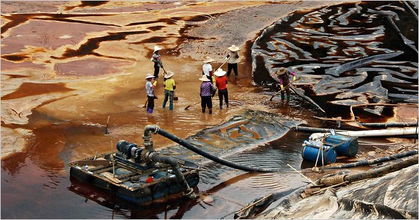 Labourers work to drain sewage water from a leaked sewage tank at a copper mine in Shanghang, Fujian province, in 2010. Reuters