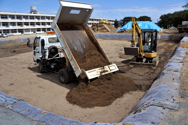 Contaminated surface soil removed from an elementary school yard is buried in Minami-Soma, Fukushima Prefecture, on 6 September 2011. Kengo Hiyoshi