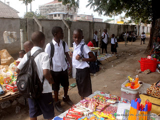 Quelques élèves du collège Boboto observent les articles étalés par les détaillants, le long de la clôture de leur école le 5/9/2011 à Kinshasa, à l’occasion de la rentrée scolaire 2011-2012. Radio Okapi/ Ph. John Bompengo