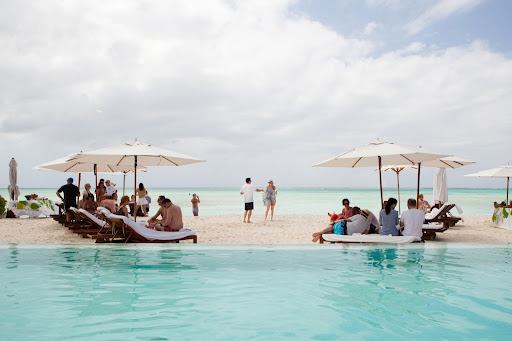 The beach party took place at the bride's parents' home. The strip of beach served as the ceremony location and reception site on the following day. The beach party took place at the bride's parents' home. The strip of beach served as the ceremony location and reception site on the following day.