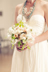 The bride held a loose bouquet of blooms, vines, and foliage. The bride held a loose bouquet of blooms, vines, and foliage.