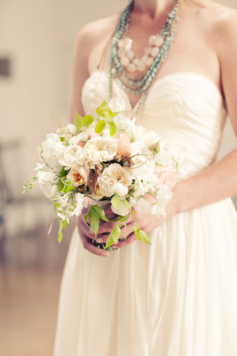 The bride held a loose bouquet of blooms, vines, and foliage. The bride held a loose bouquet of blooms, vines, and foliage.
