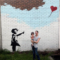 Kristy and Oscar in front of the "Banksy"
