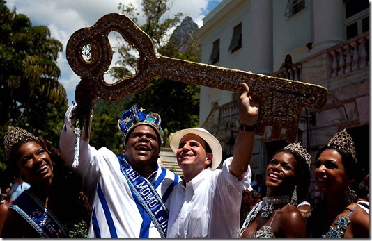 The mythical jester figure who reigns over Carnival, this year's King Momo, the crowned and costumed Milton Junior and Rio de Janeiro's Mayor Eduardo Paes hold up the key to the city at the official ceremony kicking off the five-day bash in Rio de Janeiro. Merrymakers are expected to spend $640 million and generate 250,000 jobs, according to the city's economic development department. (Felipe Dana/Associated Press)
