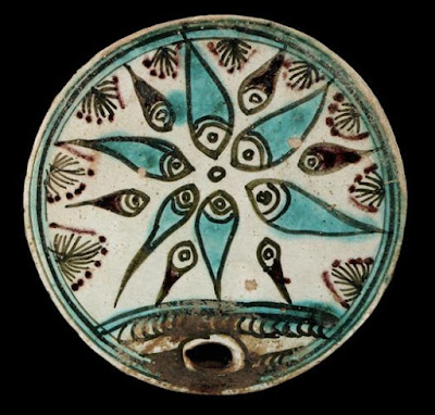 Beehive cover | Origin:  Iran | Period: late 19th-early 20th century | Details:  Among some of the more unusual ceramic objects from Islamic Iran are beehive covers, some of which date back to at least the seventeenth century. Beekeeping was widely practiced throughout the Islamic world and because bees are singled out in the Koran, Islam's holy text, they enjoy particular status among other animals and insects. The designs on the two covers on view are intended as protective and auspicious symbols and are characteristic of the more vernacular ceramic tradition that has existed in the Islamic Near East for centuries. | Type: Stone-paste painted under glaze | Size: H: 1.5  W: 22.1   D: 22.1  cm | Museum Code: S1997.124 | Photograph and description taken from Freer and the Sackler (Smithsonian) Museums.