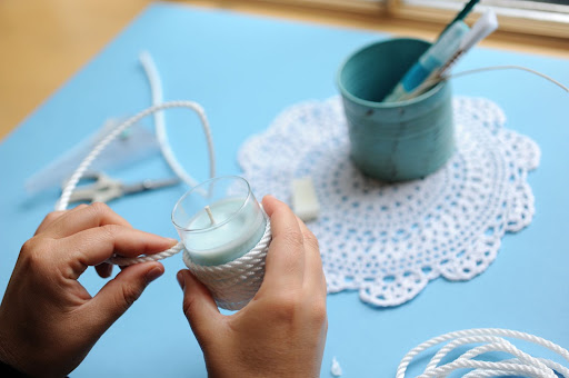 Step 10: Wind the rope around the candleholder, stopping at its lip. Snip the rope, and secure the end with a dollop of hot glue.