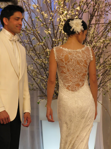 The beautiful detail on the back is shown on this Claire Pettibone dress. While the groom is wearing a white dinner jacket and black pants from Kleinfeld.