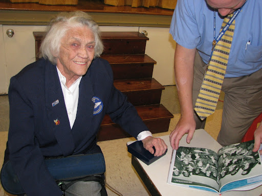 Young presents a book on the Women Airforce Service Pilots, or WASP, to the Boyd Elementary School principal.