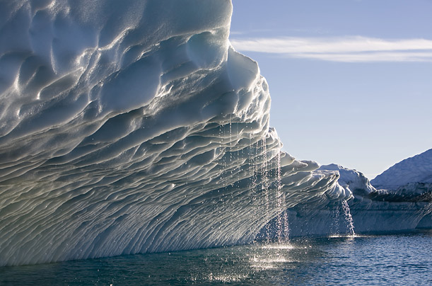 'Bergie Seltzer'. Melting water streams from iceberg calved from Ilulissat Kangerlua Glacier in Disko Bay, Greenland. When an iceberg melts, it makes a fizzing sound called "Bergie Seltzer." This sound is made when compressed air bubbles trapped in the iceberg pop. Paul Souders / Corbis