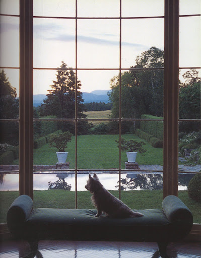 How sublime is this image of large, tall bay windows with a view over a reflecting pool.