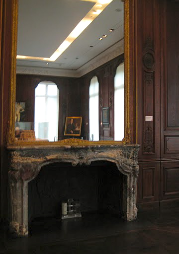 A gorgeous, gilded mirror hangs over the marble fireplace of the gallery.
