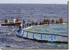 Migranti sulle gabbie per tonni