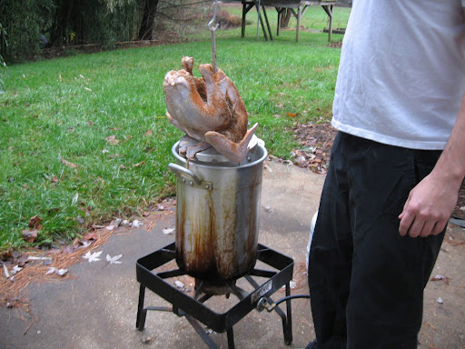 There turkey rack is connected to a turkey hook so your arm doesn't get too near the hot oil. It's a good idea to turn the flame off when slowly lowering the bird in case oil splatters.