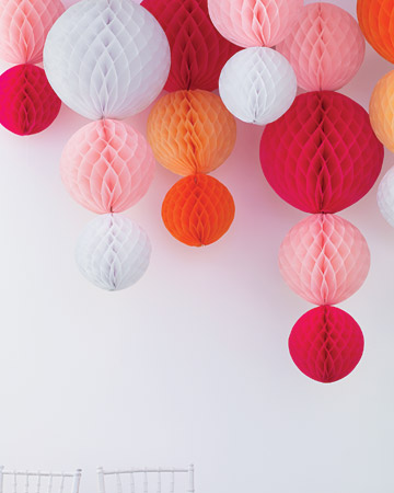 Paper chandeliers of tissue orbs stapled to narrow ribbon and hung from the ceiling will elicit oohs and aahs from your guests. (marthastewartweddings.com) Paper chandeliers of tissue orbs stapled to narrow ribbon and hung from the ceiling will elicit oohs and aahs from your guests. (marthastewartweddings.com)