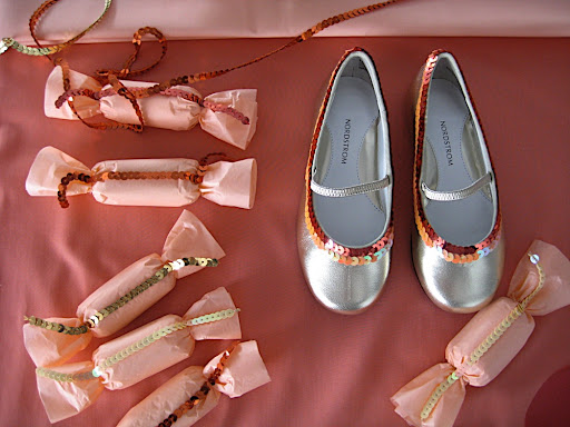 A cute shot of the favors and slippers, all decked out in sequins.