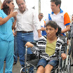 Jimmy Jairala entregando una silla de ruedas a una joven