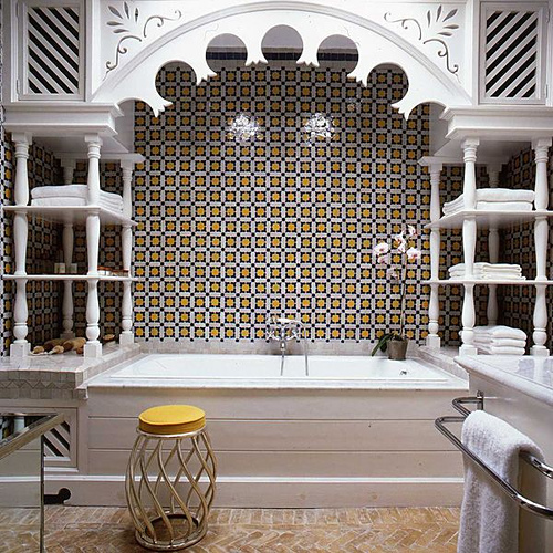 The decorative wood trim enclosing this tub pulls double duty as functional shelving and, along with the tiled floor and walls, gives the bathroom a nice Moroccan flavor.
