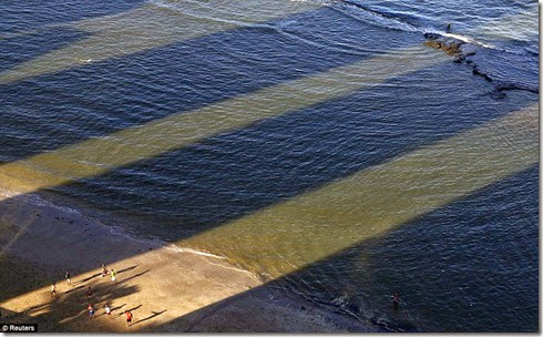 Men play soccer between the shadows of buildings on Boa Viagem Beach in Recife, Brazil, June 14 - Copy