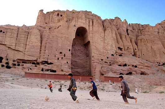 Afghan Boys Play Football in Front of Buddha of Bamyan Afghan Boys Play Football in Front of Buddha of Bamyan