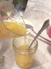 peach jam pouring into jars w spoon