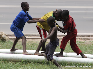 Des enfants sans demeure fixe (shégués)  jouent en face du siège de la Ceni le 12/10/2011 à Kinshasa. Radio Okapi/ Ph. John Bompengo
