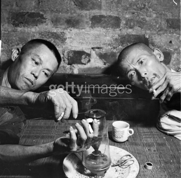 Opium Smokers circa 1955, Narcotic addicts in the British Crown Colony of Hong Kong heat a dab of opium over the flame of an oil lamp until it is dry enough to smoke from a pipe. (Photo by Evans:Three Lions:Getty Images).jpg