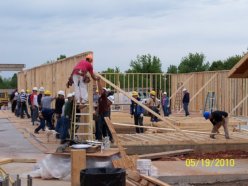 Together members raise the walls of the hall. (Photo by Art Morris)